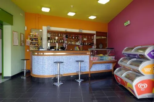 Un comptoir de bar coloré avec des tabourets et des réfrigérateurs remplis de boissons.