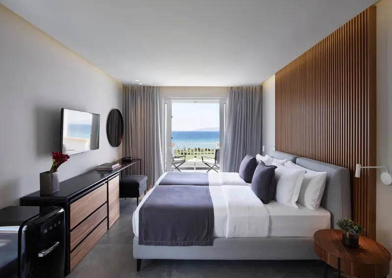 Une chambre moderne avec un lit double et vue sur la mer.