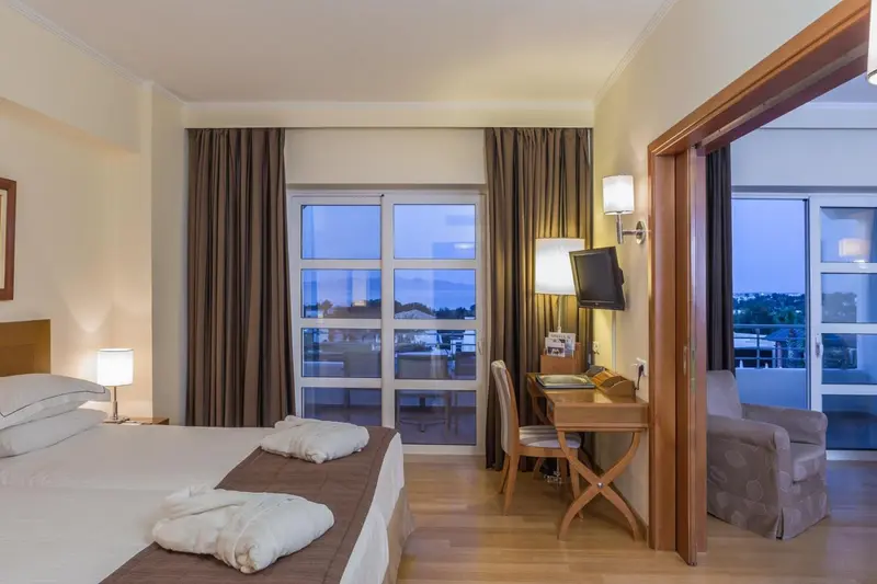 Une chambre lumineuse avec un lit double et un accès à une terrasse.