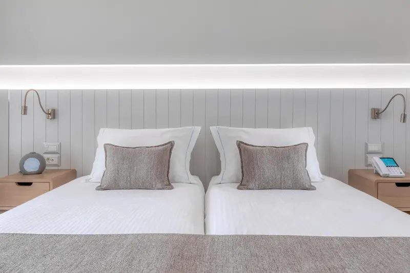Un lit double avec des oreillers et des coussins dans une chambre lumineuse.