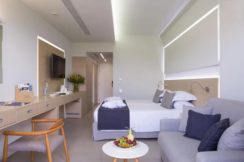 Une chambre lumineuse avec un lit et un coin salon.