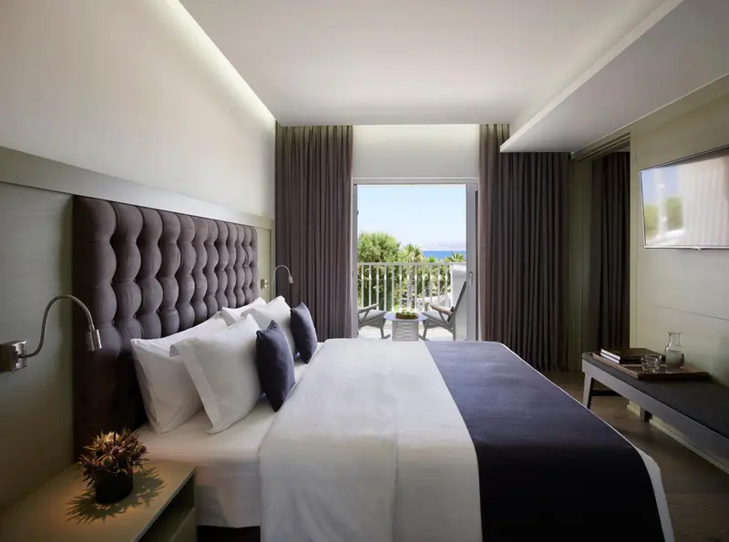 Une chambre lumineuse avec un grand lit et une vue sur la mer.