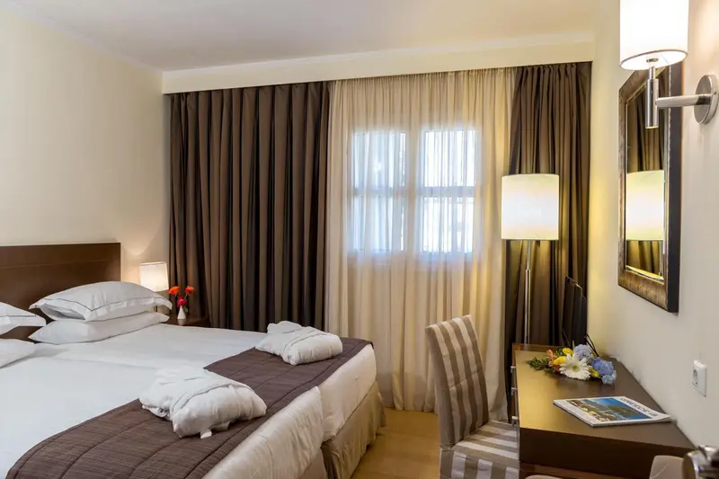 Une chambre lumineuse avec un grand lit et un bureau.