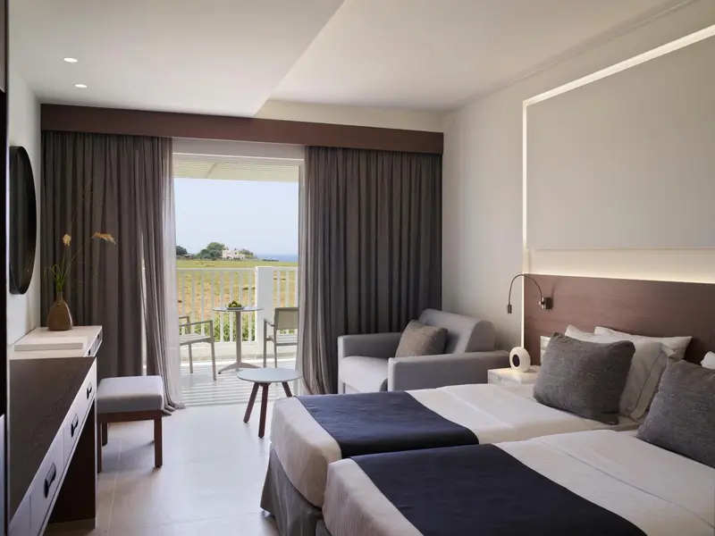 Chambre moderne avec un grand lit et un accès à un balcon.