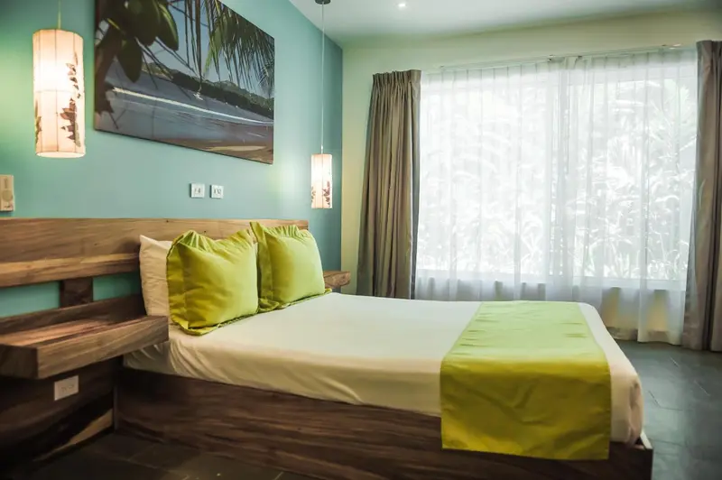 Une chambre lumineuse avec un grand lit et un tableau décoratif.