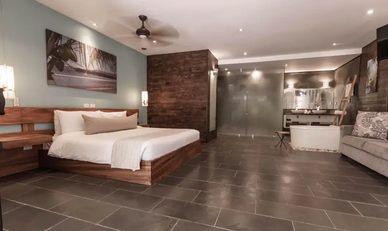 Une chambre spacieuse avec un grand lit et une salle de bain ouverte.