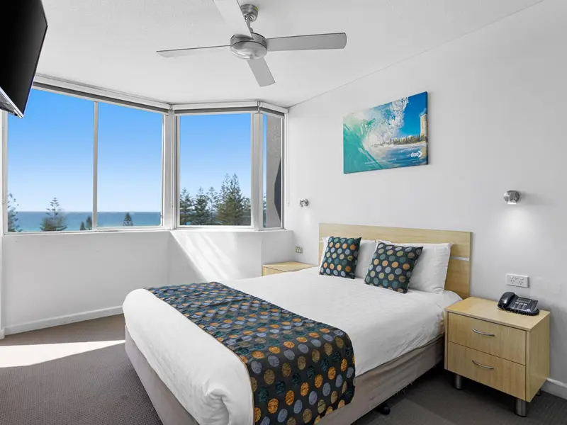 Une chambre lumineuse avec un grand lit et une vue sur la mer.