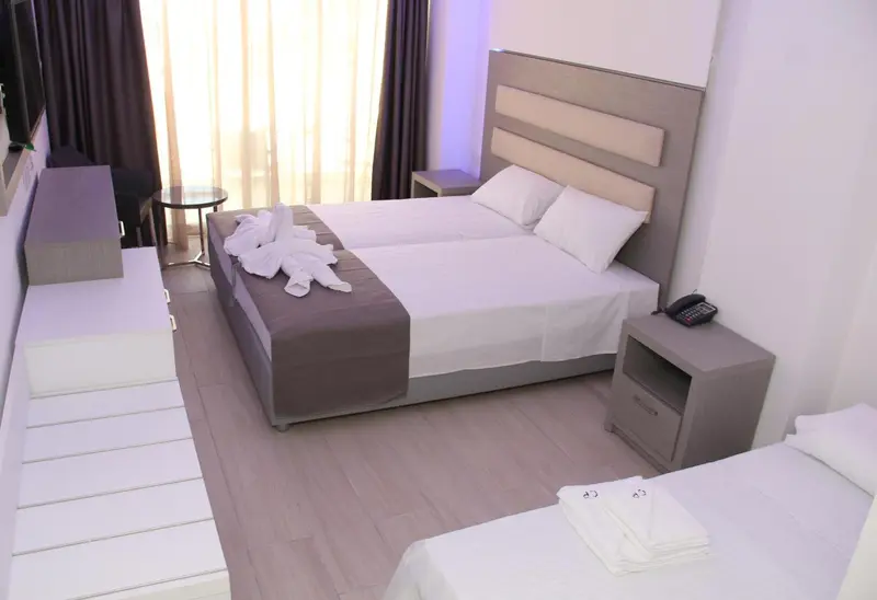 Une chambre lumineuse avec deux lits simples et une décoration sobre.
