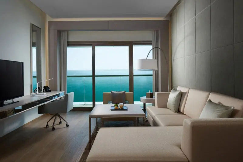 Un salon lumineux avec canapé et bureau donnant sur la mer.