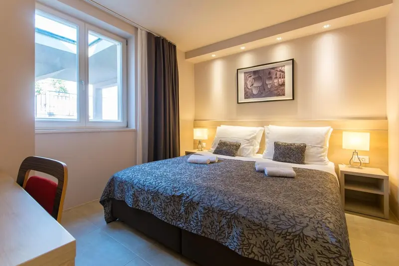 Une chambre lumineuse avec un grand lit et des oreillers décorés.