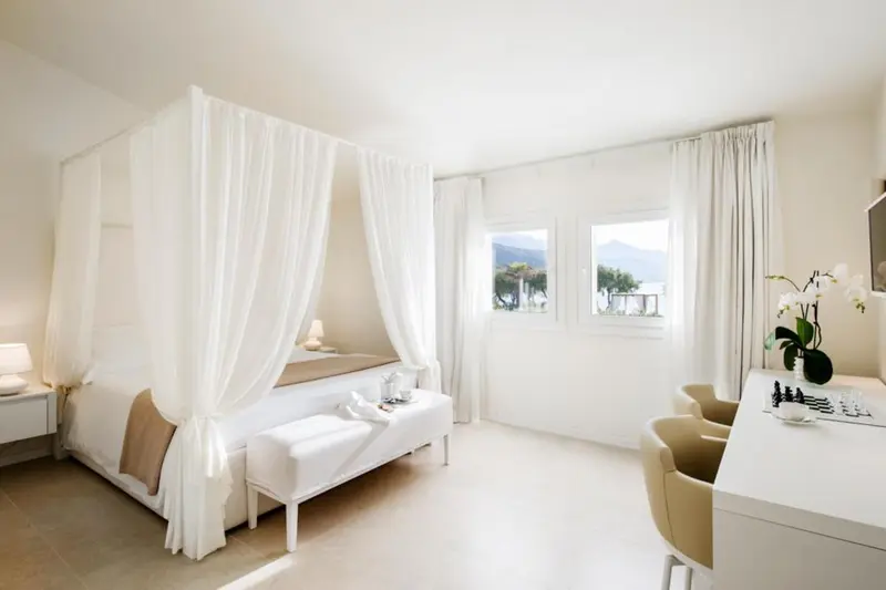Chambre lumineuse avec un lit à baldaquin et un coin repas.