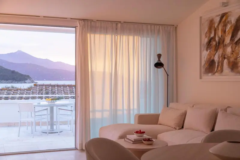 Espace de détente lumineux avec canapé et vue sur la mer.