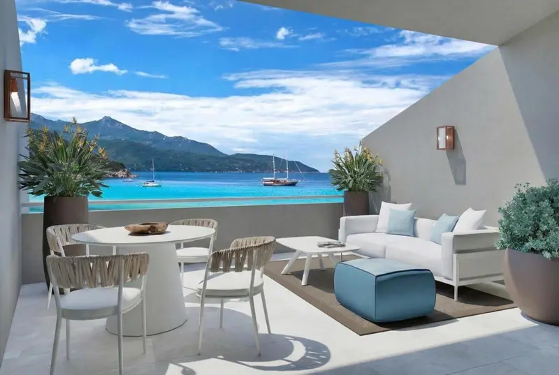 Terrasse aménagée avec salon et table à manger donnant sur une vue mer et montagne.