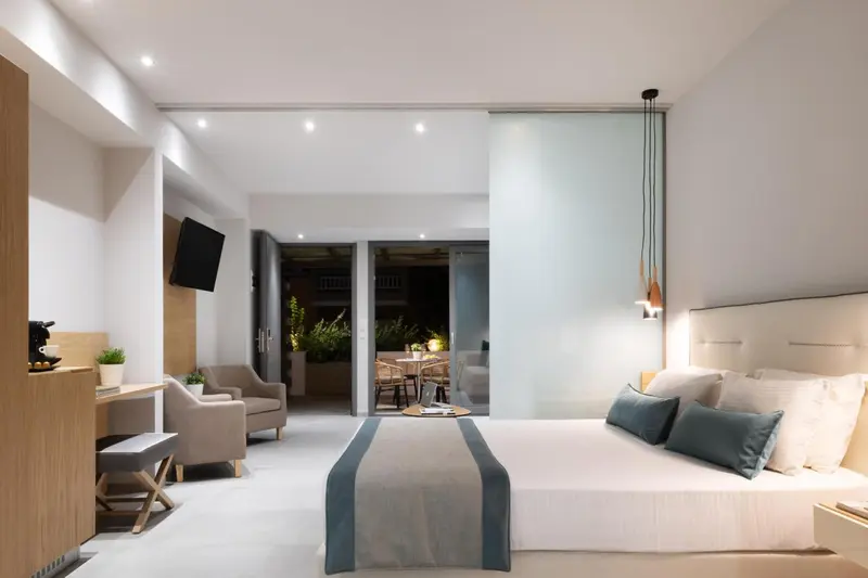 Une chambre lumineuse avec un lit double et un espace salon.