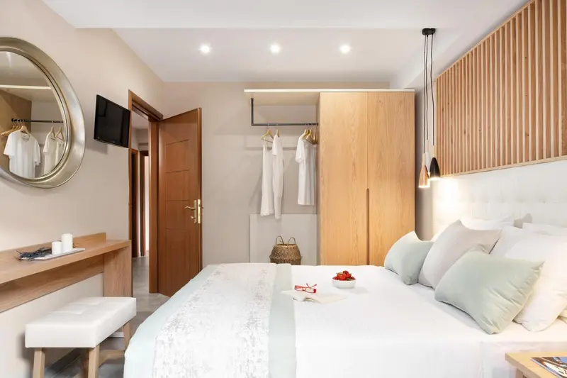 Une chambre lumineuse avec un grand lit et un espace rangement.