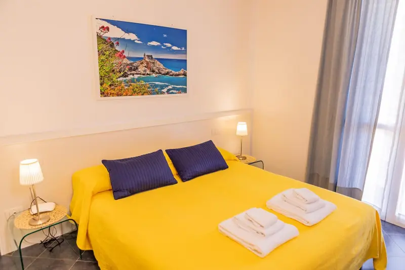 Une chambre lumineuse avec un grand lit recouvert d'un drap jaune vif.