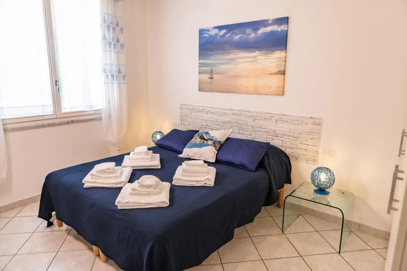 Une chambre avec un grand lit recouvert de coussins et de serviettes.