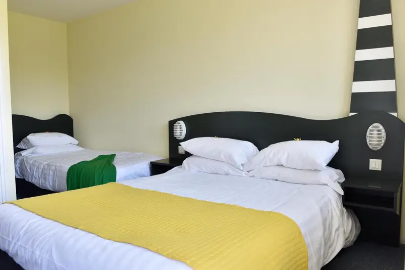 Chambre avec deux lits simples et une décoration colorée.