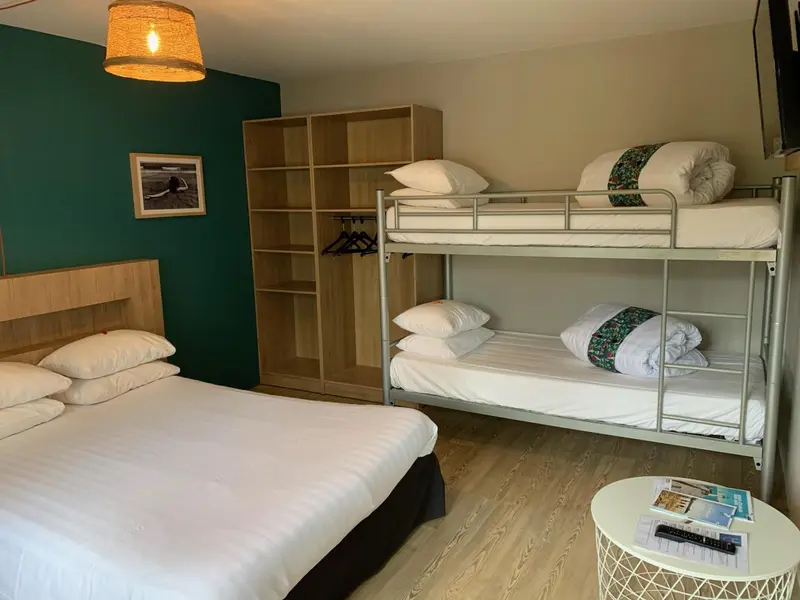 Une chambre avec un lit double et un lit superposé.
