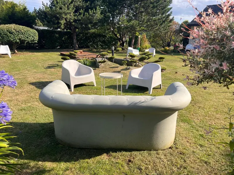 Mobilier de jardin blanc disposé sur une pelouse verdoyante.