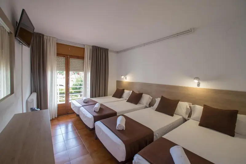 Une chambre d'hôtel avec deux lits simples et une fenêtre.
