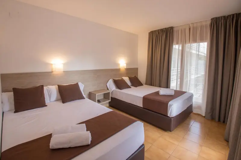 Une chambre avec deux lits doubles et des oreillers.