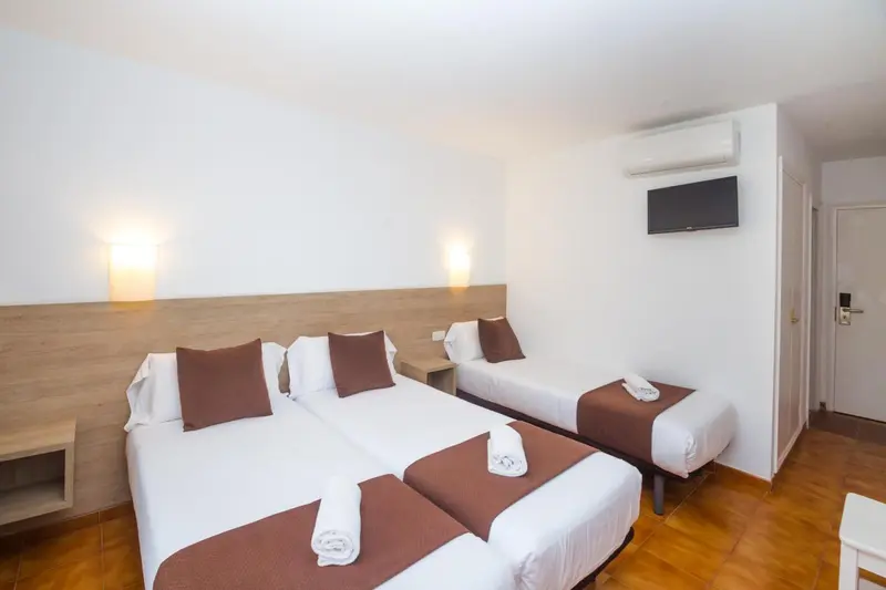 Une chambre lumineuse avec deux lits simples et une décoration sobre.