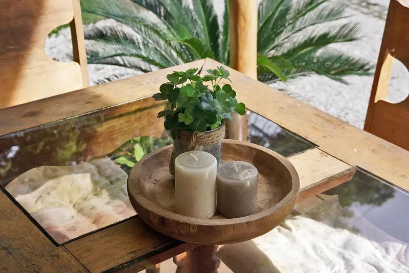 Une table en bois avec des bougies et une plante en pot.