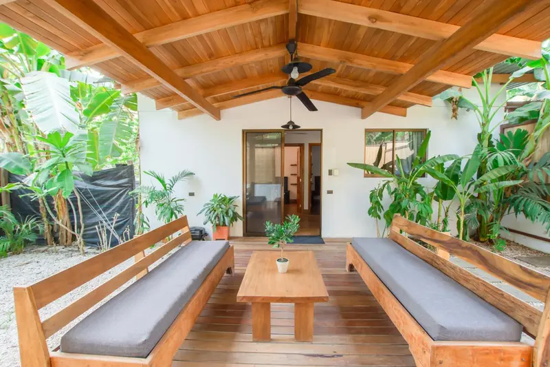 Espace extérieur aménagé avec des bancs en bois et une table basse.