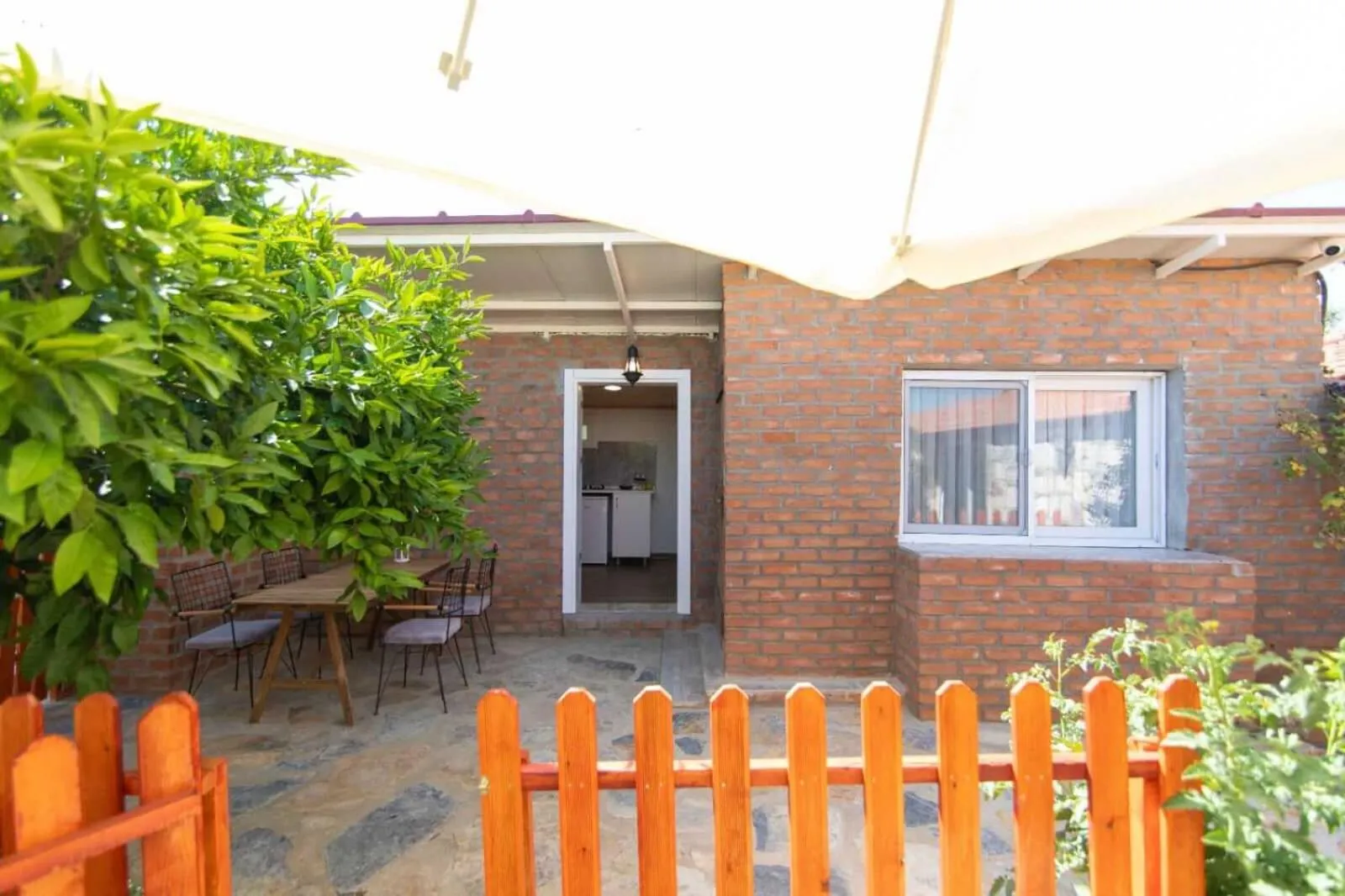 Terrasse ombragée donnant sur une entrée de logement.