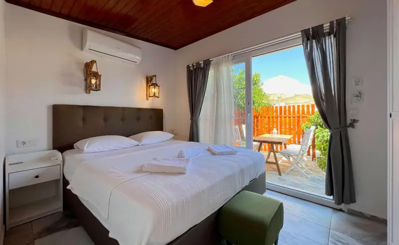 Une chambre lumineuse avec un grand lit et un accès à une terrasse.