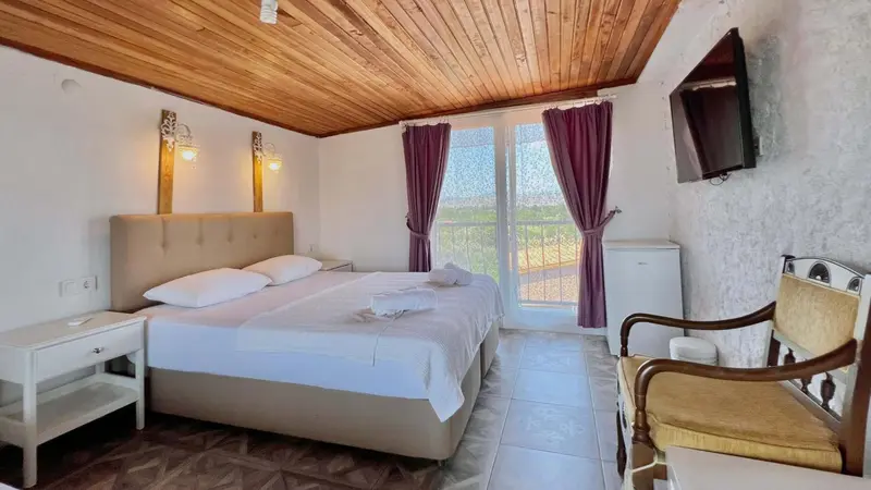 Une chambre lumineuse avec un lit double et un coin salon.