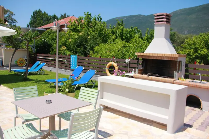 Espace extérieur aménagé avec mobilier de jardin et barbecue.