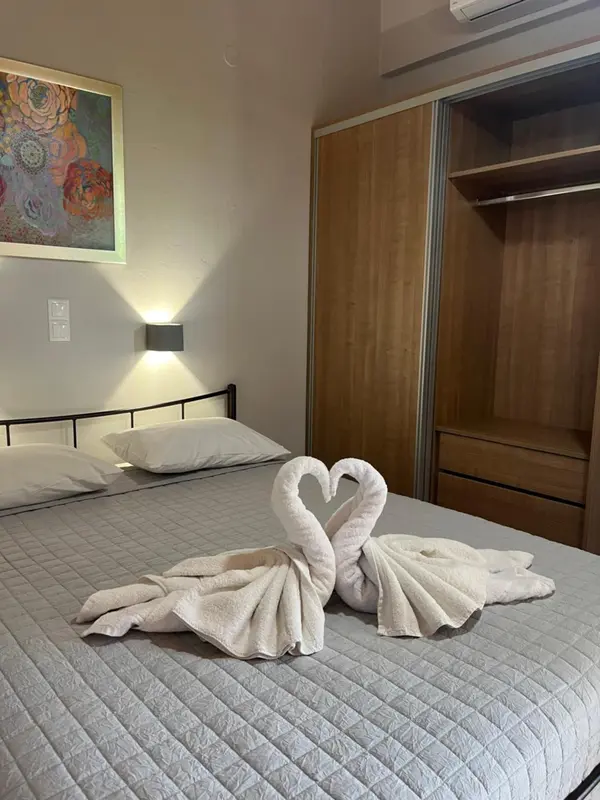 Une chambre avec un lit décoré de serviettes en forme de cygnes.