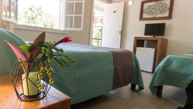 Une chambre lumineuse avec deux lits simples et une décoration florale.