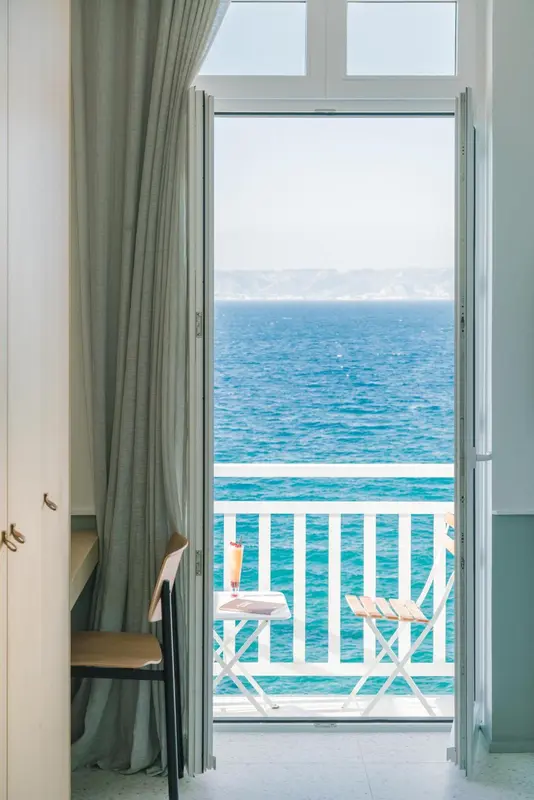 Vue sur la mer depuis un balcon ensoleillé.
