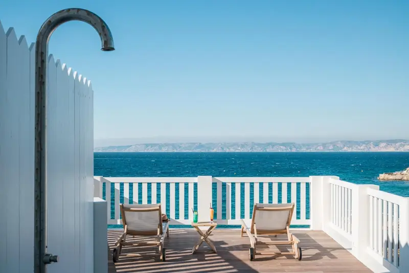 Terrasse avec douche extérieure et vue sur la mer.