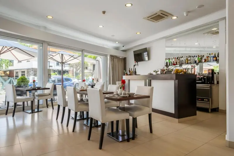 Une salle lumineuse avec des tables et un comptoir de bar.