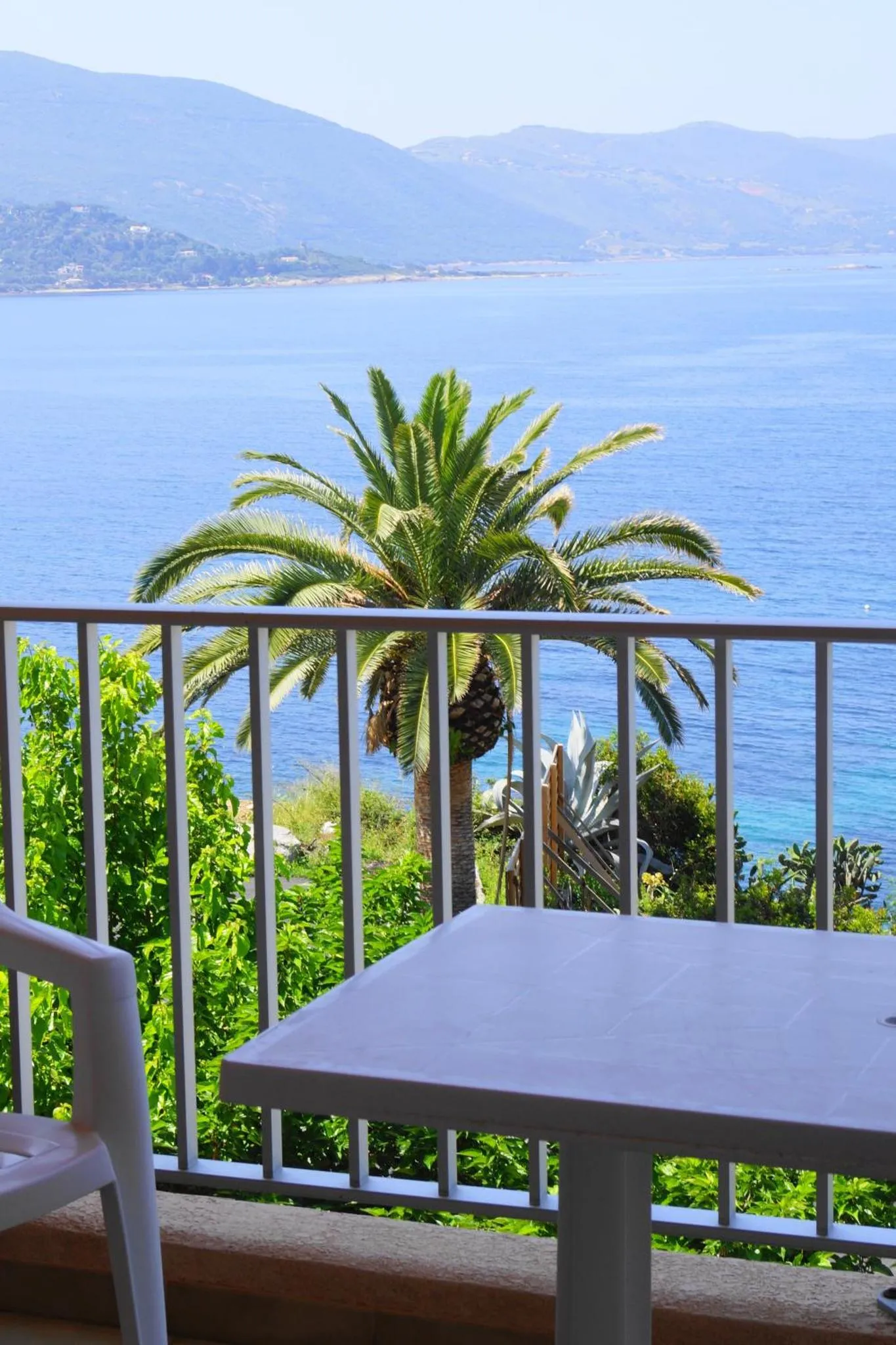 Vue sur la mer depuis une terrasse ensoleillée.