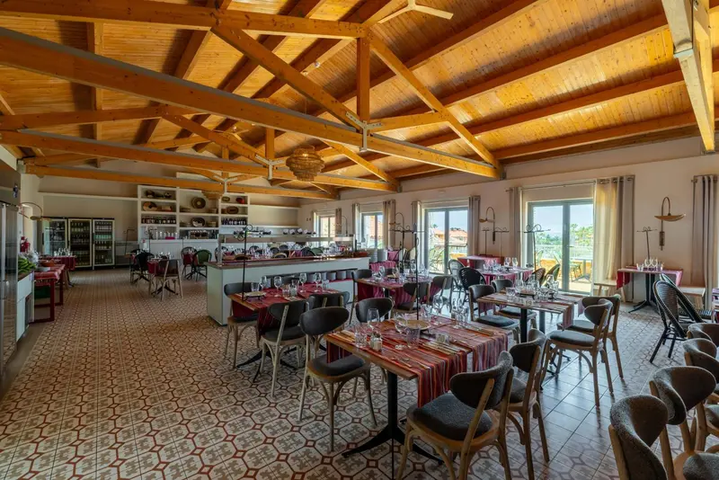 Une salle lumineuse avec des tables dressées pour un repas.