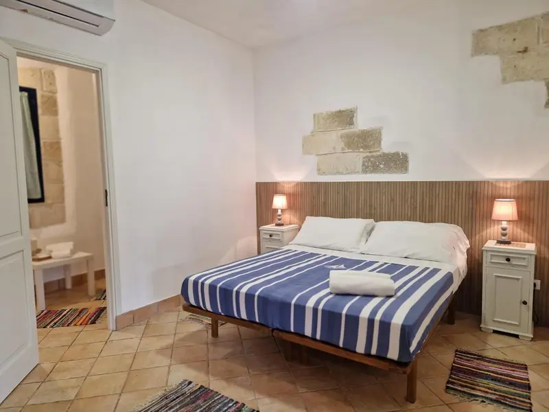 Une chambre lumineuse avec un lit double et une décoration sobre.