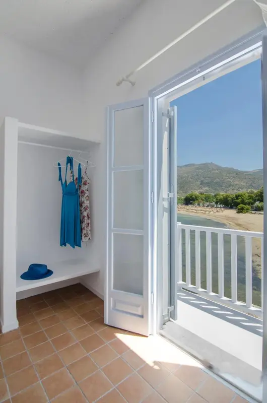Une chambre lumineuse s'ouvre sur une vue dégagée sur la mer et la plage.