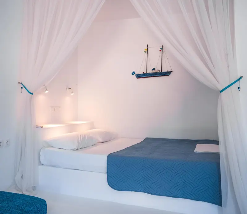 Lit simple dans une chambre lumineuse avec décoration maritime.
