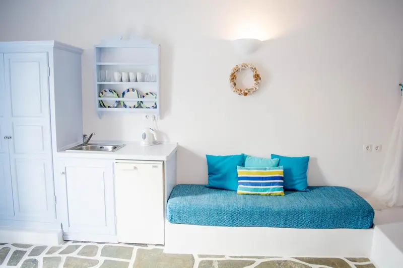 Un espace de repos avec une kitchenette intégrée et des coussins colorés.