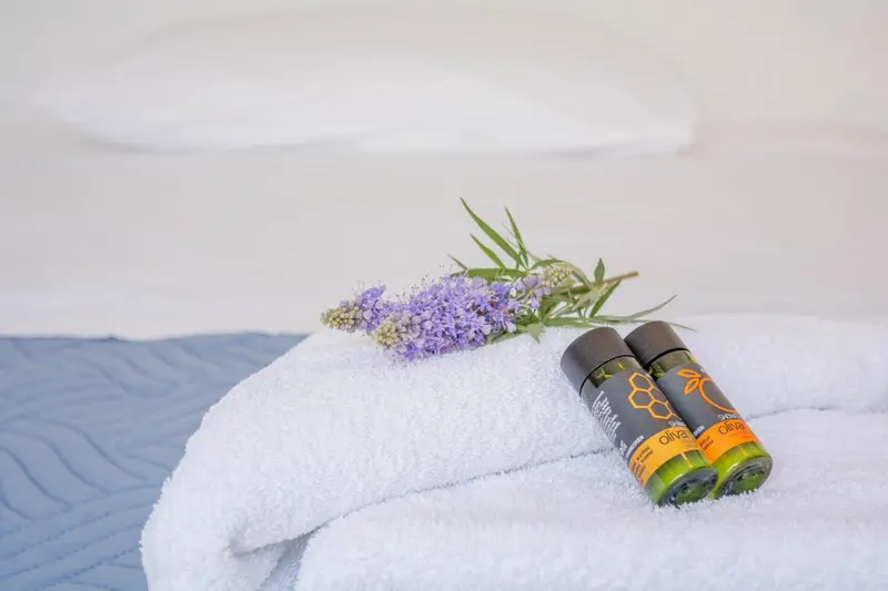 Serviettes blanches pliées avec des produits de toilette sur un lit.