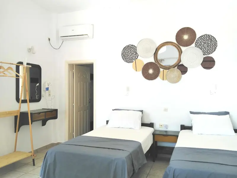 Une chambre lumineuse avec deux lits simples et une décoration murale.