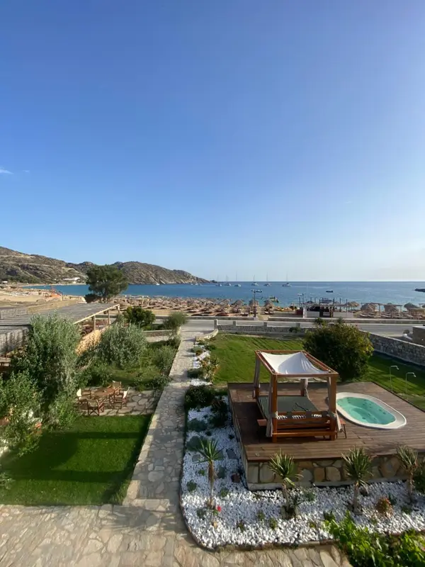 Terrasse aménagée avec jacuzzi et vue sur la mer et la plage.