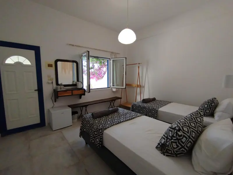 Une chambre lumineuse avec un lit double et une vue sur l'extérieur.
