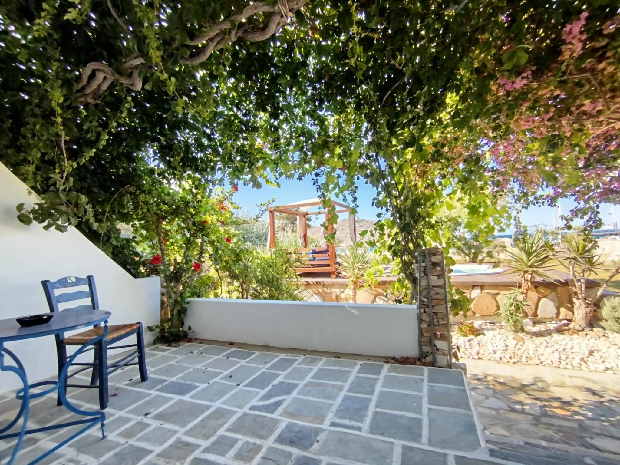 Une terrasse ombragée avec une table et des chaises offre un espace de détente extérieur.