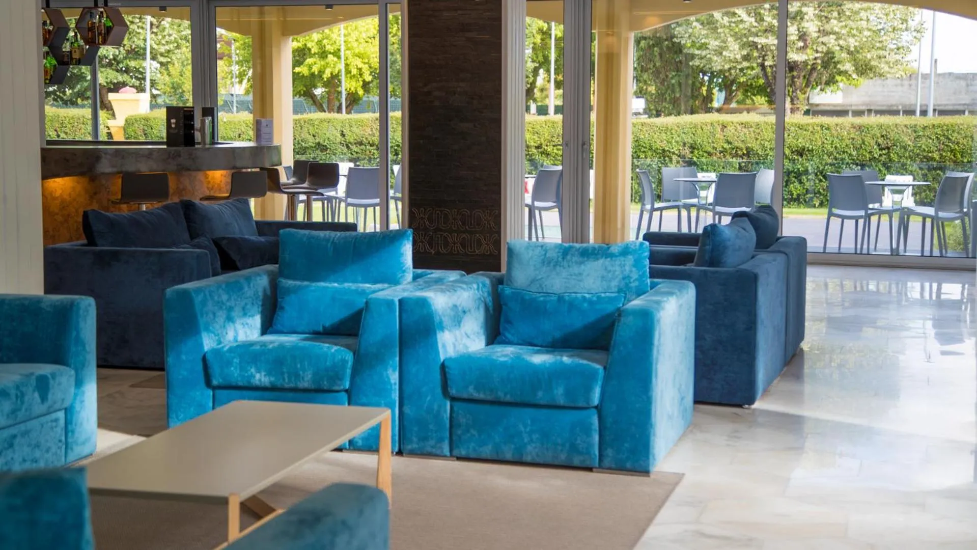 Un espace de détente intérieur avec des canapés bleus et des fauteuils confortables.